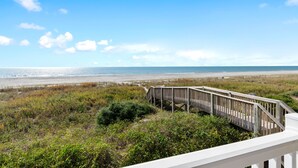 A beach view with a wooden walkway leading to the shore. - Isle Oasis. Oceanfront. Elevator, Heatable Pool,  Drct Bch Access. Grt Location. (Holden Beach)