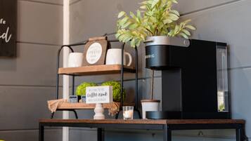 A coffee machine on a shelf with a sign that reads "Welcome to the coffee nook."
