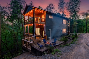 A cabin with a deck, outdoor seating, and a fire pit. - Romantic Cabin Retreat By Ghosal Luxury Lodging (Gatlinburg)