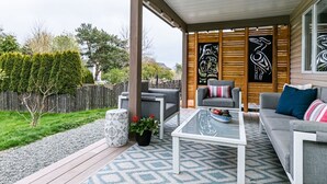 An outdoor patio area with a sofa, chairs, and a coffee table. - Lovely 2 bedroom suite steps from The beach (Victoria)