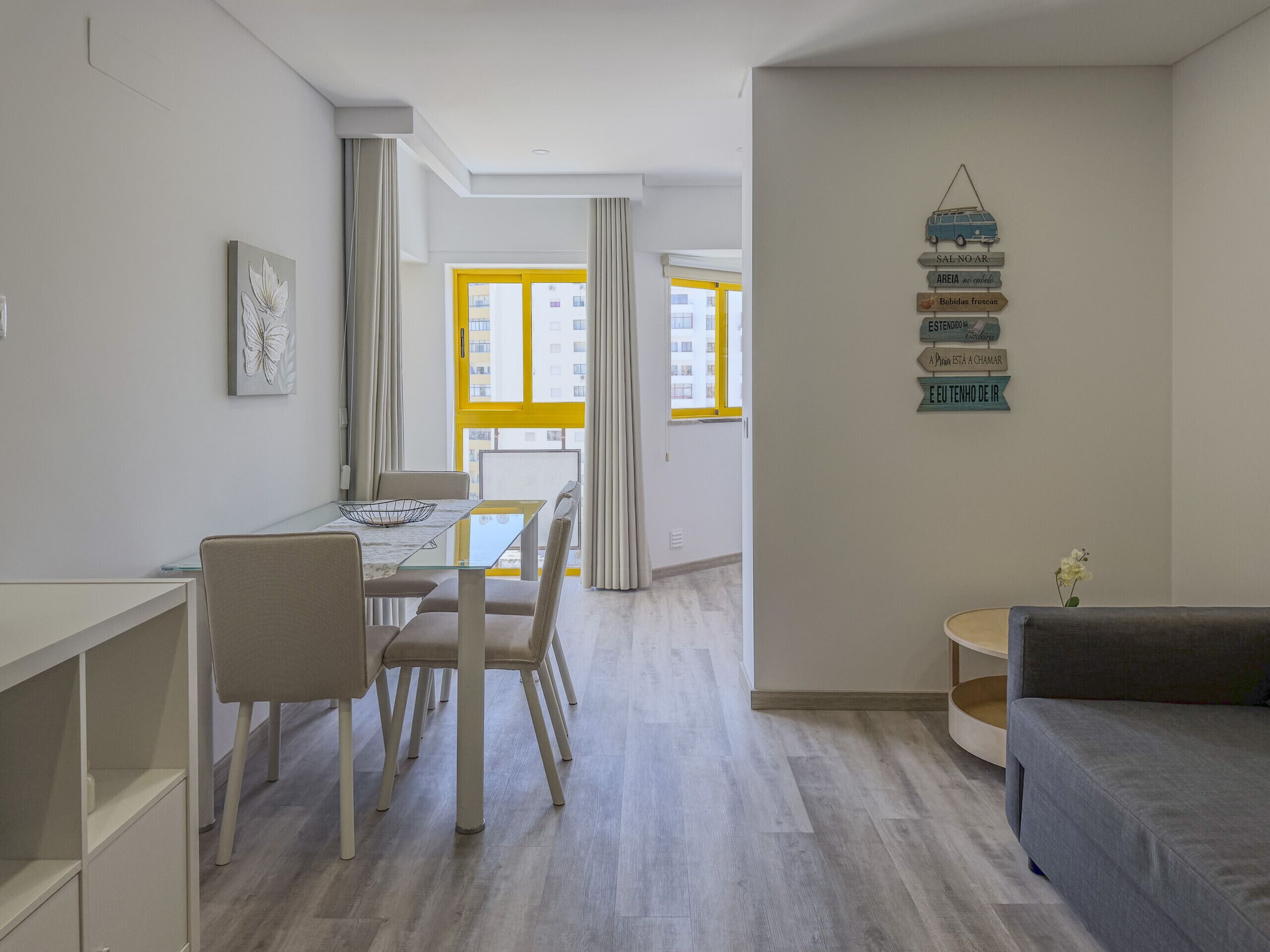 Un apartamento moderno con comedor, sofá y una pared con indicaciones.
