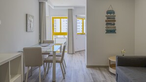 A modern apartment with a dining area, a sofa, and a wall with directional signs. - #150 Praia da Rocha by Home Holidays (Portimão)