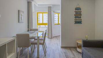 Un apartamento moderno con comedor, sofá y una pared con indicaciones.