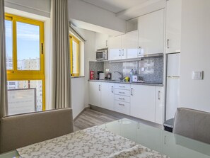 A compact kitchen with white cabinets, a microwave, and a small countertop. - #150 Praia da Rocha by Home Holidays (Portimão)