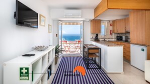 Eine moderne Küche mit Holzausstattung, einem Einbauofen und Blick auf das Meer.