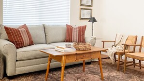A living room with a sofa, a coffee table, a lamp, and a patterned rug. - Near Downtown, Convenient to Restaurants, 2 Cruiser Bikes To Explore With! (Prescott)