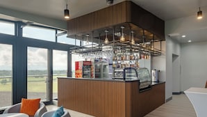 A modern bar area with a wooden counter, glassware, and a view of the countryside. - Kekehyu Business Hotel (Valencia)