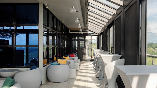 A modern interior with white seating, large windows, and a view of the outdoors. - Kekehyu Business Hotel (Valencia)