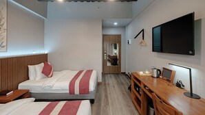 A hotel room with two beds, a wooden desk, a flat-screen TV, and a mirror. - Kekehyu Business Hotel (Valencia)