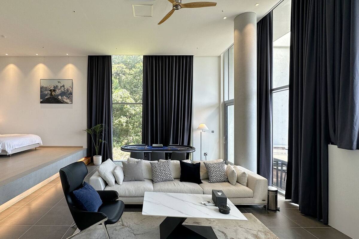 Una habitación de hotel moderna con cama, sofá y una pequeña mesa para juegos.