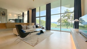 Una sala de estar moderna con un sofá, una mesa de centro y vistas a una piscina.