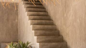 A concrete staircase with a woven canopy overhead.