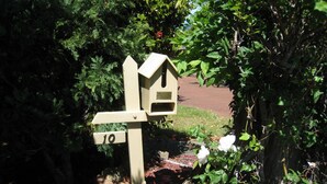 Un panneau indicateur en bois, avec une boîte aux lettres et un panneau portant le numéro « 10 ».