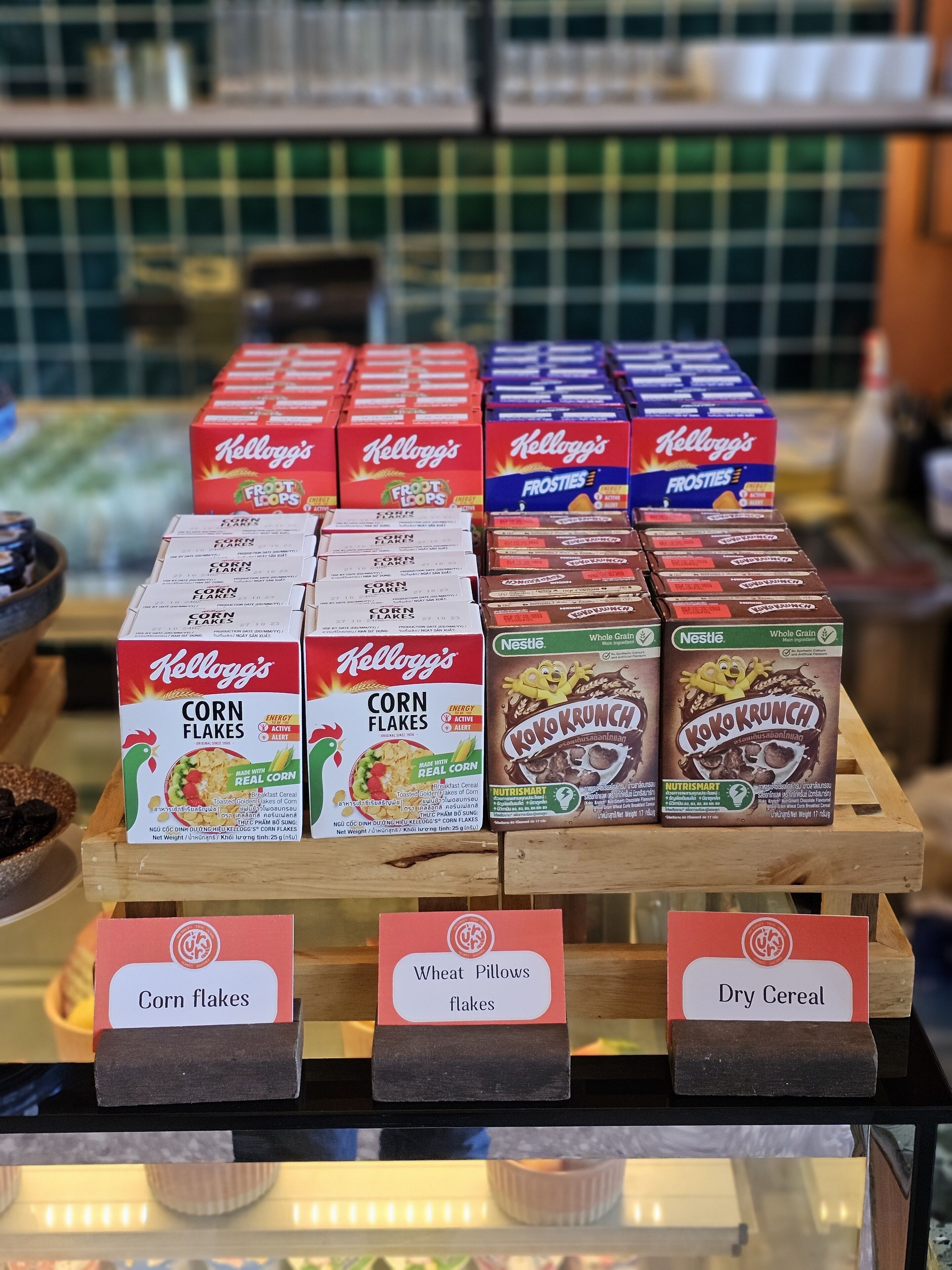 Eine Präsentation von Getreideboxen, darunter Kellogg's Corn Flakes, Nestle's Koko Krunch und andere Trockengebäcke.