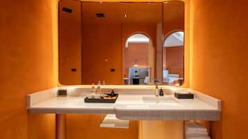 Une salle de bain moderne avec deux lavabos, un grand miroir et un porte-serviettes.