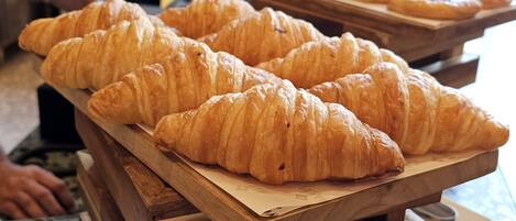 A display of croissants on wooden stands in a bakery.