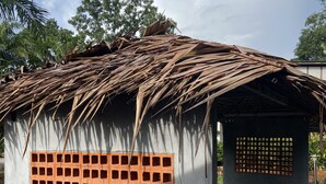 Una pequeña construcción con techo de paja y pared de entramado.