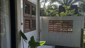Un baño con bañera, una planta en maceta y un revestimiento de azulejos.