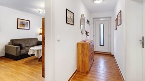 Ein Flur mit einem Holzschrank, einer Couch und gerahmten Bildern an den Wänden.