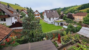 Et boligområde med huse, en grøn græsplæne og en have med forskellige planter.