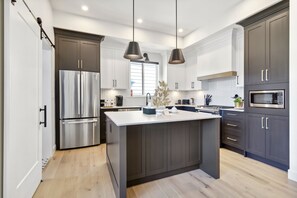 Enjoy cooking in this well-equipped kitchen with a central island, stainless steel appliances, and a large window.