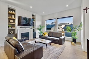 Relax in this stylish living room with a large flat-screen TV, comfortable sofa, and beautiful views of the surrounding neighborhood.