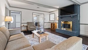 A spacious living room with a fireplace, a sofa set, and a coffee table.
