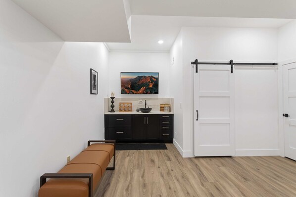 A modern room with a wooden floor, a brown sofa, a black cabinet, a painting, and a sliding door. - Beech Mountain Cabin on Golf Course (Beech Mountain)