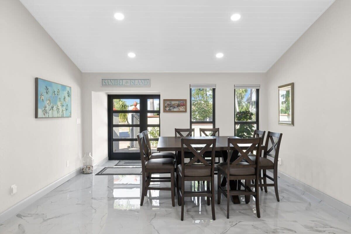 A dining area with a marble floor, a table with chairs, and a sign on the wall.