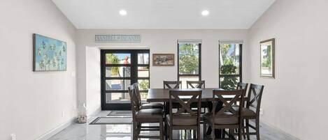 A dining area with a marble floor, a table with chairs, and a sign on the wall.