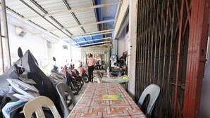 A room with a long table, chairs, and a row of motorcycles parked against the wall. - SPOT ON 93276 Fendi 2 Homestay SyariahNearPelabuhan Feri Batam Centre (Batam)