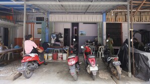 A covered outdoor area with several motorcycles parked under a metal roof. - SPOT ON 93276 Fendi 2 Homestay SyariahNearPelabuhan Feri Batam Centre (Batam)