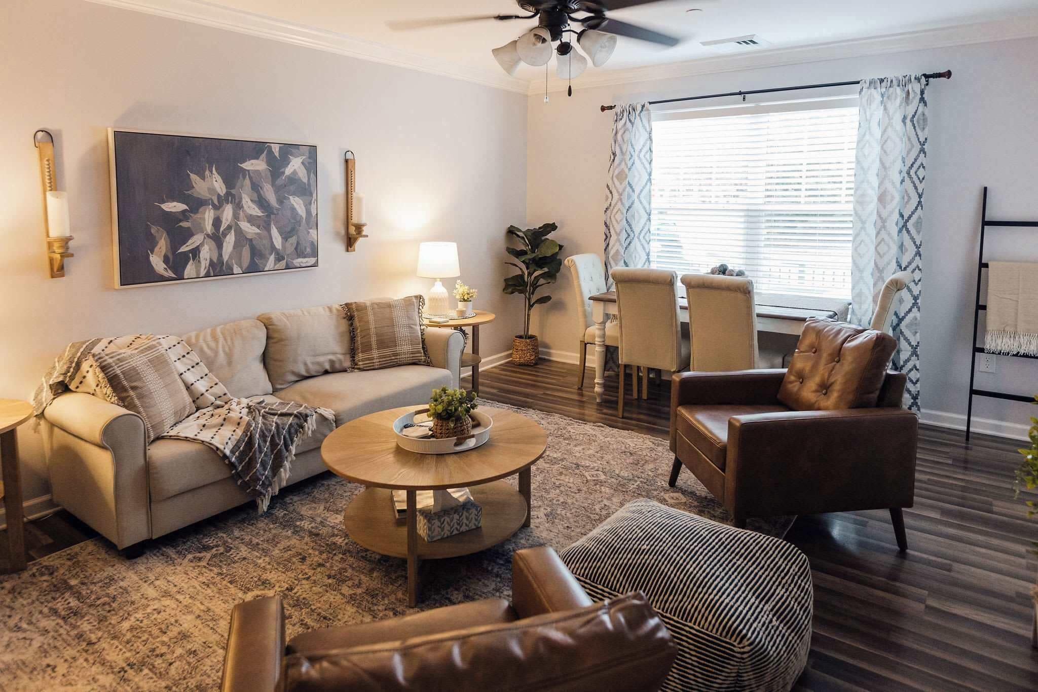 Ein Wohnzimmer mit einer Couch, Sesseln, einem Couchtisch und einem Essbereich.