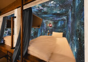 A room with a bed, a nightstand, and a wall mural depicting a starry night sky. - The Centurion Sauna Rest & Stay Sapporo Male Only (Sapporo)