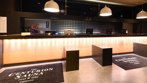 A reception area with a counter, pendant lighting, and a wall displaying a 'FRONT' sign. - The Centurion Sauna Rest & Stay Sapporo Male Only (Sapporo)
