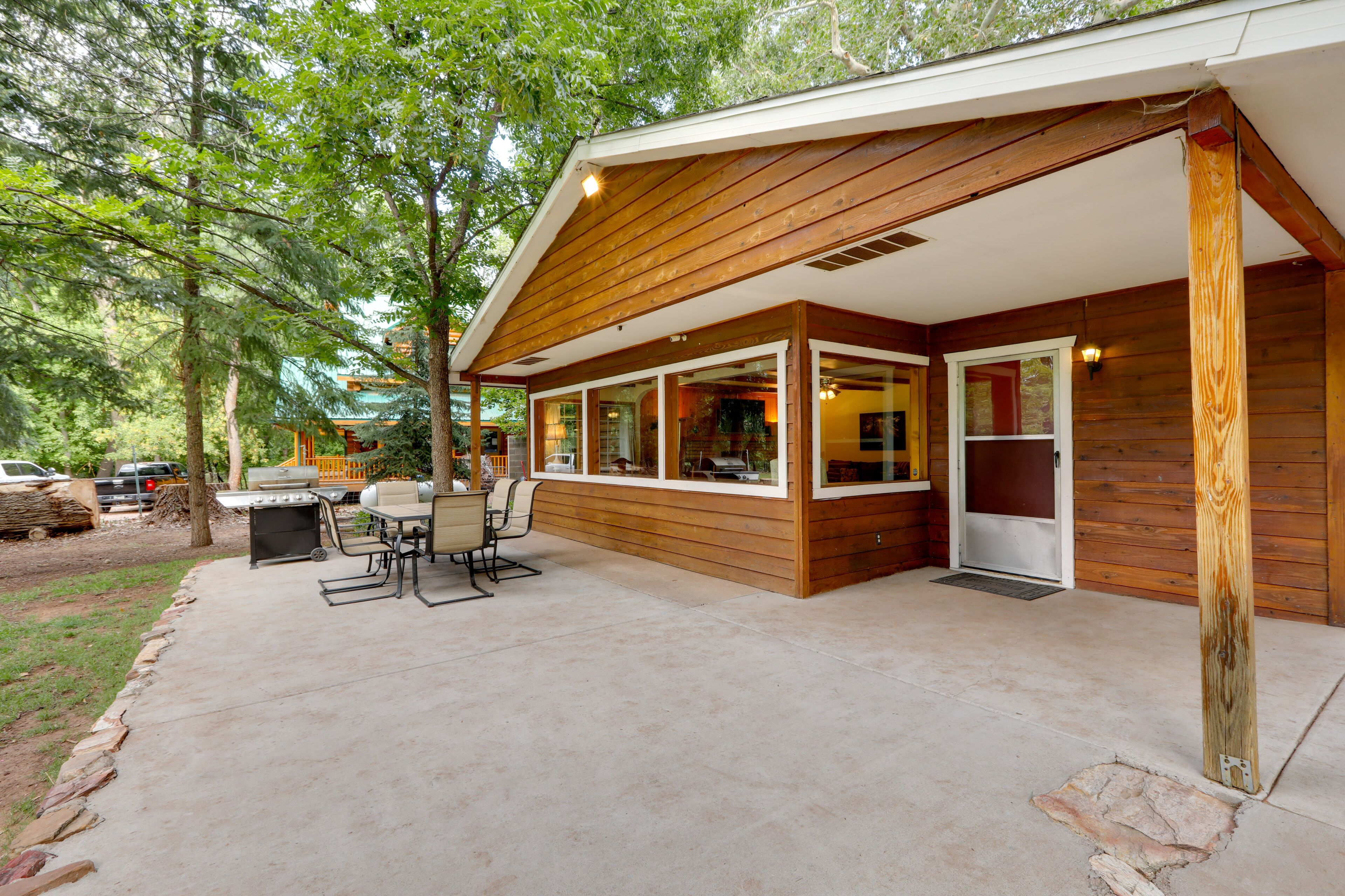 A wooden house with a covered patio, large windows, and a door.