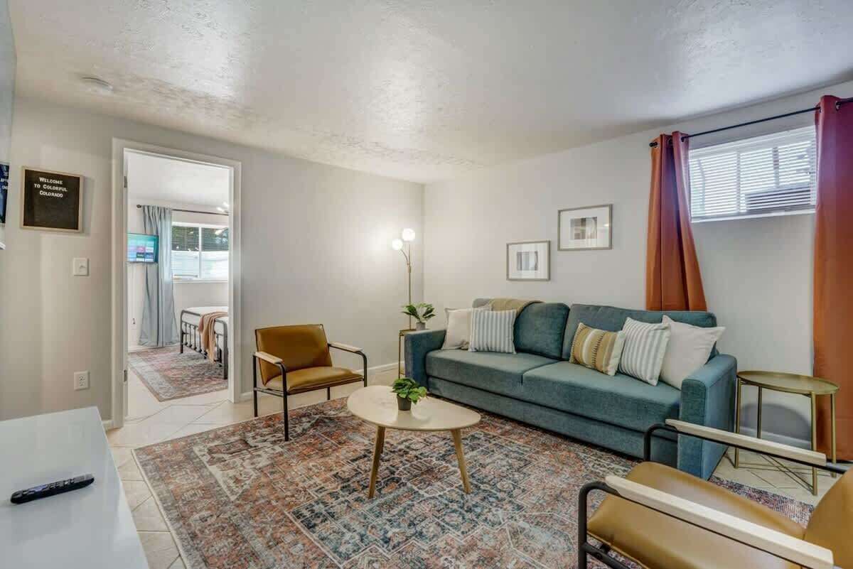 Una sala de estar con sofá, sillones, una mesa de centro y televisor.