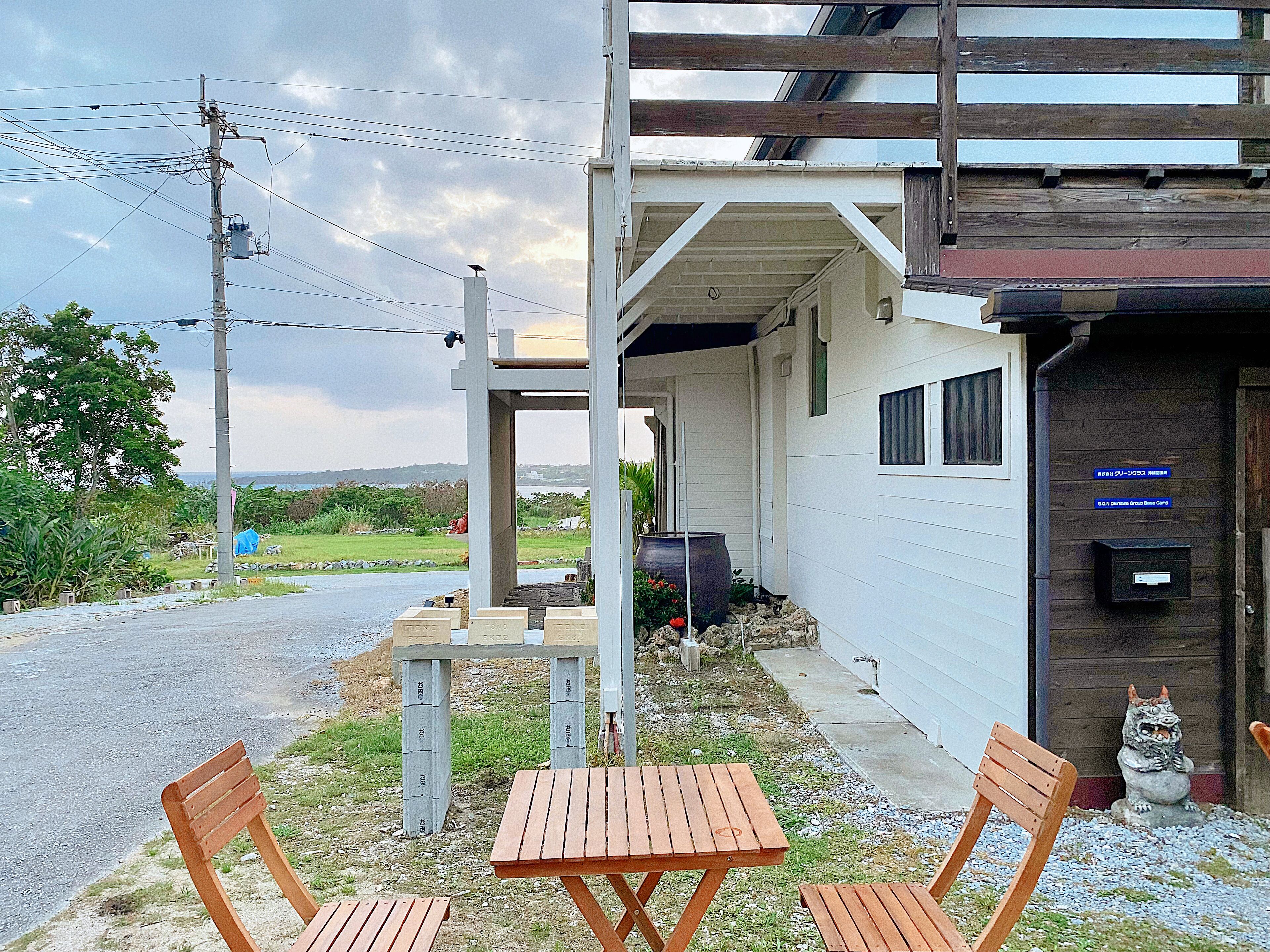 A building with a covered outdoor seating area, a mailbox, and a statue.