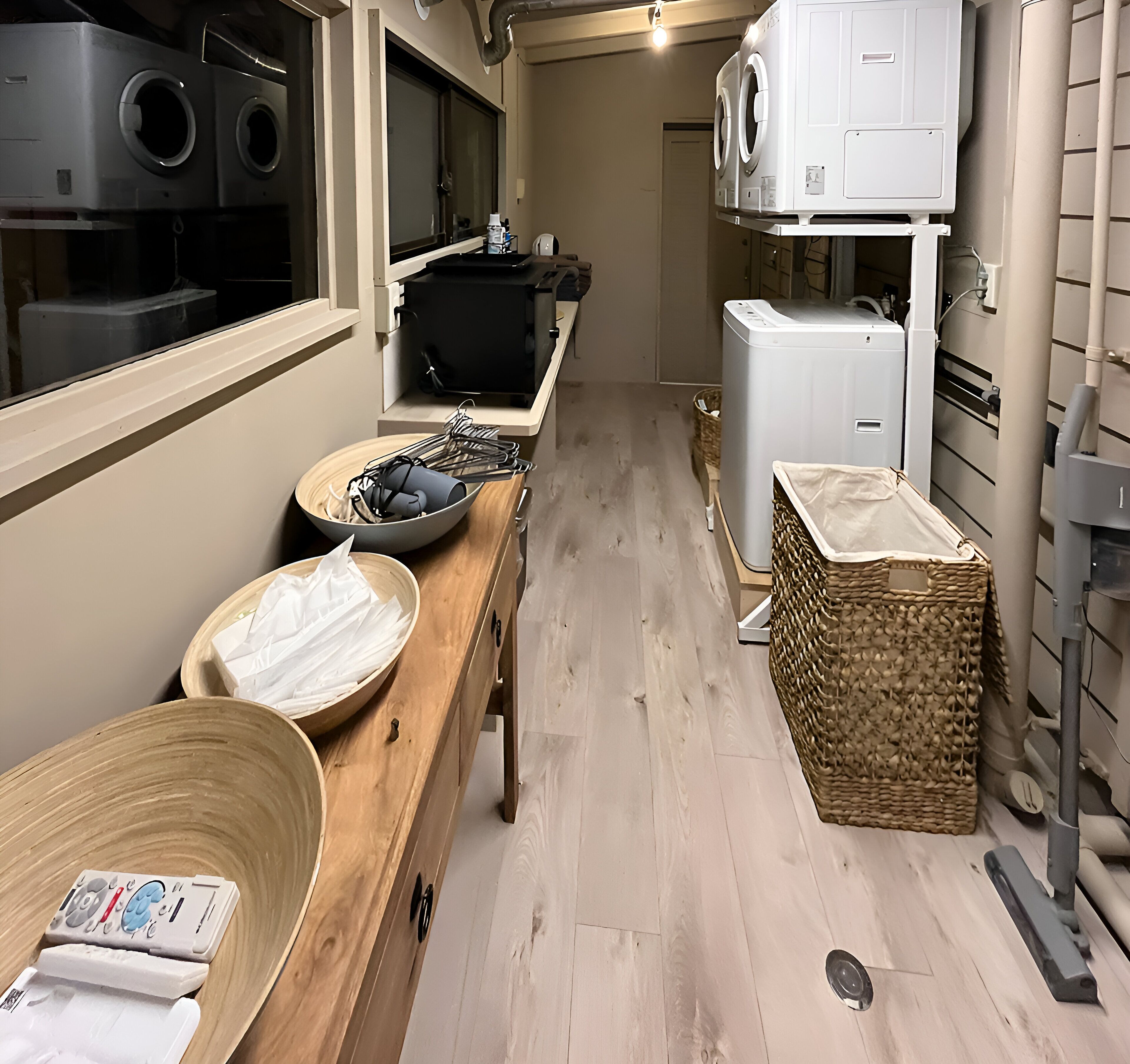 A kitchen with a wooden countertop, a large bowl, a basket, and a washing machine.