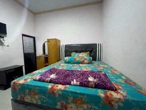 A bedroom with a bed, a wardrobe, and a desk.