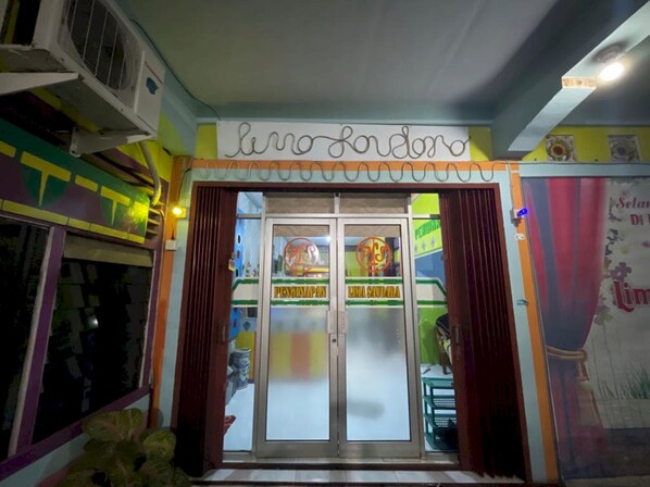 A restaurant entrance with a sign reading "luno londra" and two glass doors labeled "PENGINAPAN" and "LIMA SAUDARA".