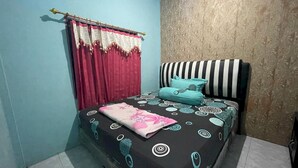 A bedroom with a bed, curtains, and a patterned wall. - Hotel O Lima Saudara Syariah (Padang)