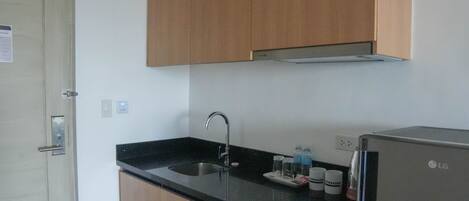 A kitchen with wooden cabinets, a stainless steel sink, and an LG refrigerator.