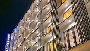 A modern hotel with a prominent 'Copenhagen' sign, multiple balconies, and a well-lit entrance. - Copenhagen Residences (Ormoc)
