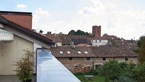 A rooftop terrace with a view of traditional buildings and a tower in the distance. - Entire Accommodation in Castelfranco Veneto (Castelfranco Veneto)
