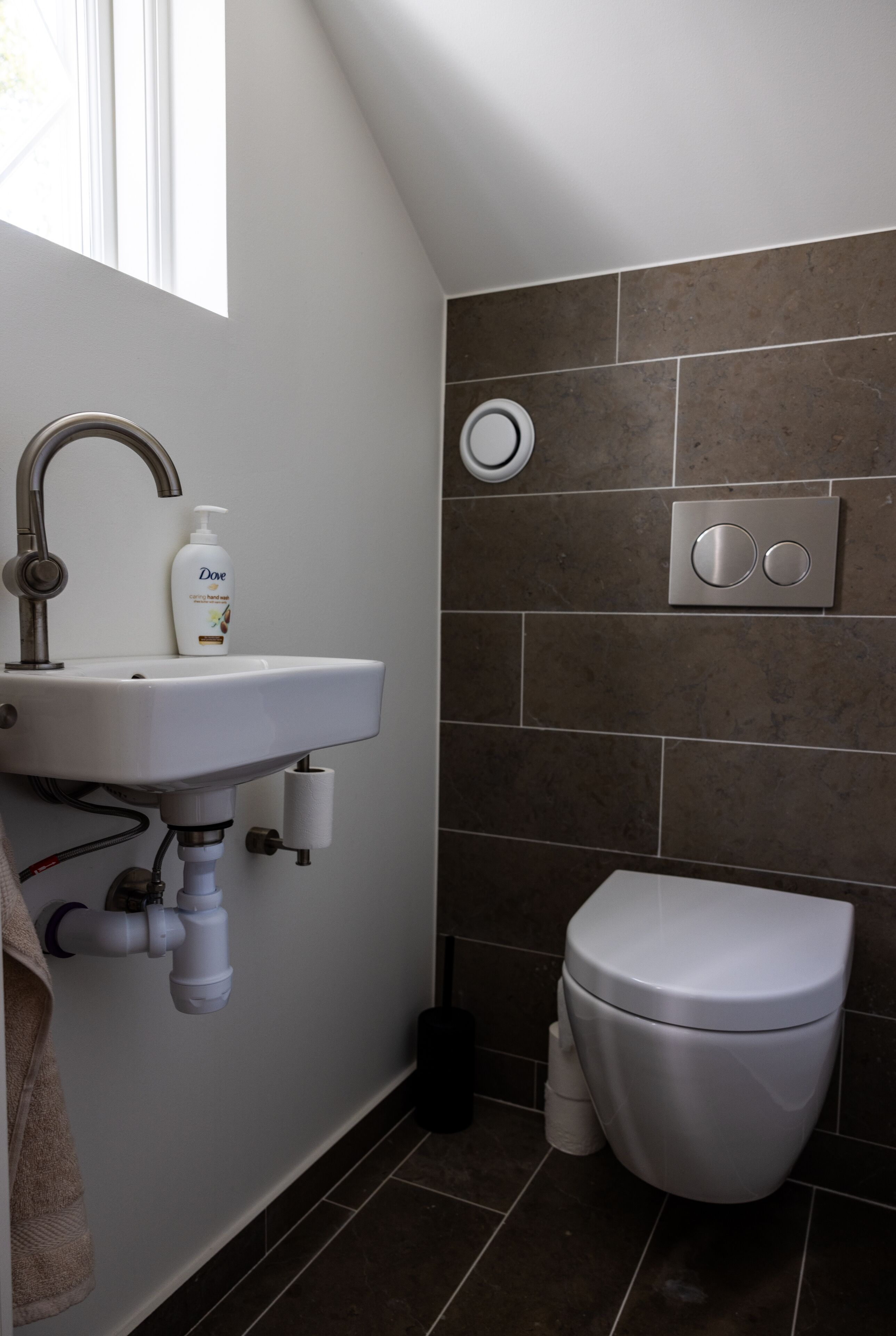 A bathroom with a white sink, a toilet, and a shower area.