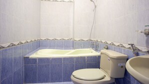 A bathroom with a bathtub, toilet, and sink.