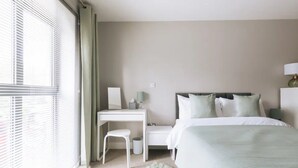 Ein modernes Schlafzimmer mit Bett, Schreibtisch und Stuhl.