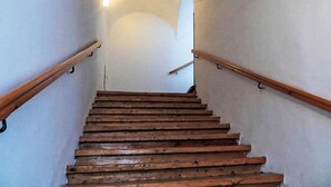 A wooden staircase with a handrail on both sides, leading to a higher floor.