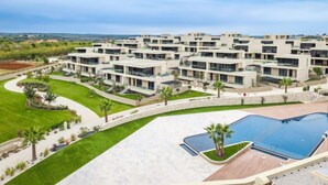 A modern apartment complex with multiple buildings, a swimming pool, and landscaped areas.